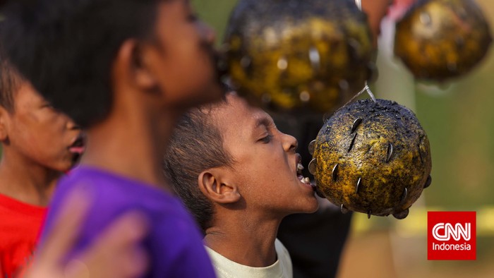 Anak-anak mengikuti perlombaan khas 17-an gigit koin yang digelar dalam acara festival Ciliwung di Jakarta, Selain memperingati Hari Kemerdekaan, Festival Ciliwung diadakan untuk mensyukuri kondisi Sungai Ciliwung yang dinilai sudah lebih baik. CNN Indoneia/Adhi Wicaksono.