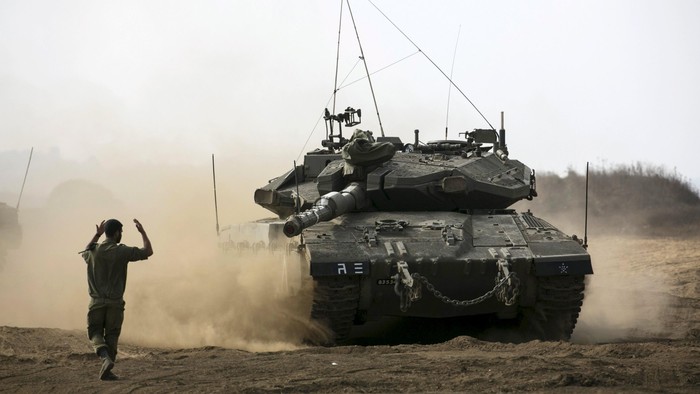 An Israeli soldier directs a tank during an exercise in the Israeli-occupied Golan Heights, near the ceasefire line between Israel and Syria, August 21, 2015. An Israeli air strike on the Syrian Golan Heights killed at least four Palestinian militants responsible for Thursdays rocket fire on an Israeli village, an Israeli defense official said on Friday. REUTERS/Baz Ratner