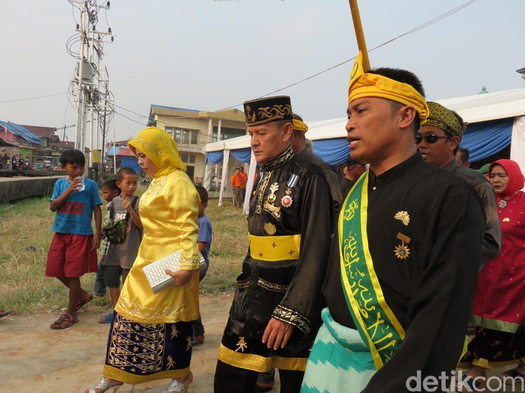 Presiden Jokowi Pakai Baju Adat dan Disambut Sultan Pontianak di Di titik kedua Jokowi dan rombongan kemudian menaiki kapal karnaval Menyusuri Sungai Kapuas para warga semakin semarak menyaksikan dari tepi