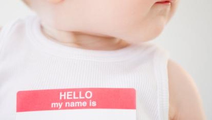 seorang bayi memakai name tag