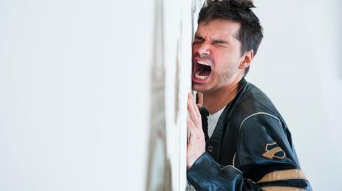 Frustrated mid adult man screaming at the wall