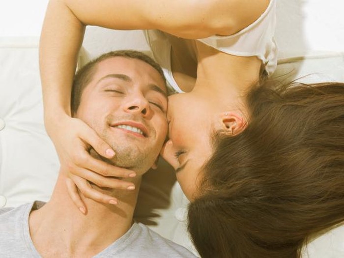 Young couple lying back to back in bed