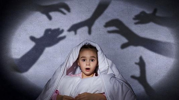 Frightened Woman in Bed with the Sheets Pulled Up to her Face
