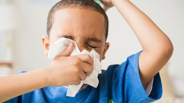 ilustrasi flu Mixed race boy blowing his nose