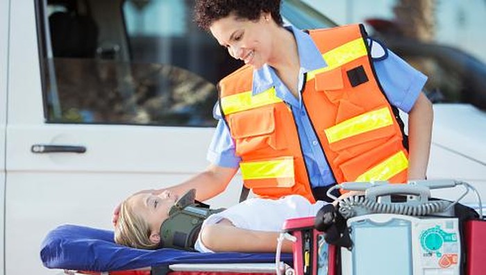 Paramedic examining patient on stretcher