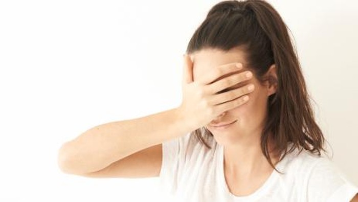 Portrait of girl covering her eyes with her hand