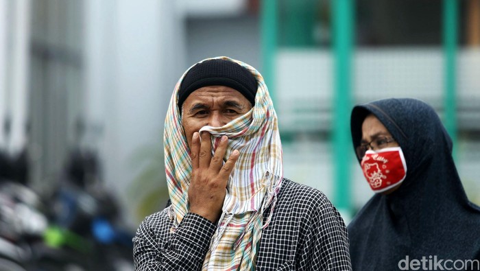 Orang Dengan Masker Warga Padang, Sumatera Barat, beraktifitas di tengah kepulan kabut asap, Kamis (08/10/2015). Masih diselimutinya kawasan sekitaran padang membuat sejumlah warga harus mengenakan masker saat beraktivitas. Grandyos Zafna/detikcom.