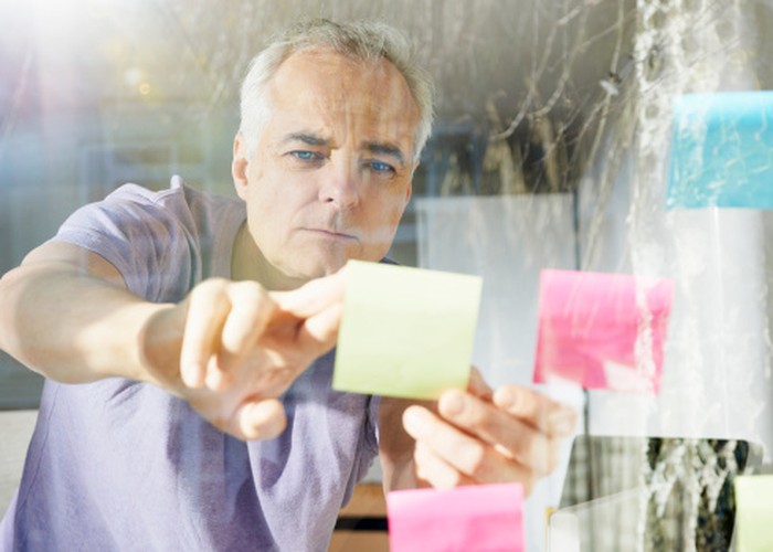 mature man sticking down lost it note