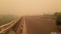 Kabut asap saat siang hari di Palangkaraya semakin menggila. Pemandangan terlihat menguning redup dan matahari siang bolong bersinar merah gelap seperti sore hari. (Foto: Firdaus/detikHealth)