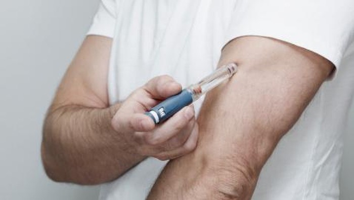 Man Injecting Himself with Insulin Pen in Arm.