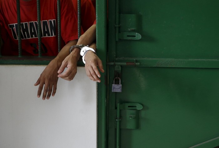 Wartawan Inggris Neil Bonner (C) dan Becky Prosser (R) berbicara dengan rekan mereka di dalam sel sebelum sidang mereka di Pengadilan Negeri Batam di Batam, Indonesia Kepulauan Riau, 19 Oktober 2015. Media lokal melaporkan bahwa jaksa penuntut umum di Indonesia menunda hukuman dari dua wartawan Inggris, yang menurut pihak berwenang imigrasi ditahan untuk membuat film dokumenter tentang pembajakan sementara pada wisatawan visa, hingga Kamis. REUTERS / Beawiharta