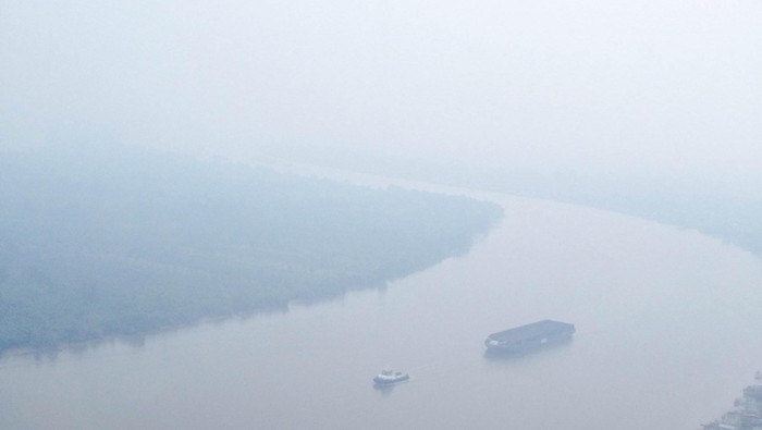 Kabut asap akibat kebakaran hutan dan lahan masih menyelimuti Kalimantan. Salah satunya adalah Sungai Barito dan kawasan kalimantan yang terlihat buram karena diselimuti asap pekat.
