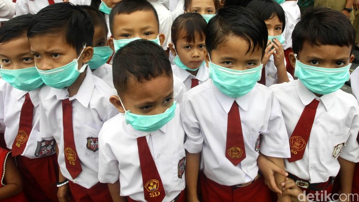 Siswa dan siswi SDN 181/IV Kota Jambi, Selasa (26/10/2015) tetap melakukan proses belajar meski sekolah mereka diselimuti kabut asap tebal. Para murid tampak mengenakan masker. Hasan Alhabshy/detikcom.