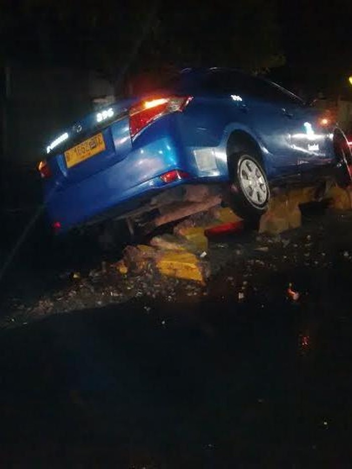 Sebuah Taksi Nyangkut di Pembatas Busway di Warung Buncit