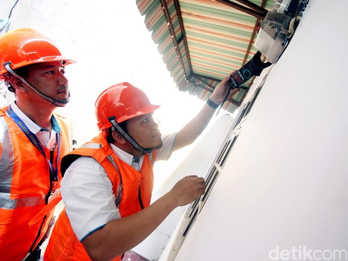 Petugas PLN Distribusi Jakarta Raya, Area Bulungan, tengah melakukan pemeriksaan tegangan pada alat pembatas dan pengukur di rumah pelanggan R1. 900 VA, di daerah Gandaria Utara, Kebayoran Lama, Jakarta Selatan, Selasa (17/11/2015).
Pemerintah telah memutuskan untuk tetap memberikan subsidi listrik kepada seluruh pelanggan PLN dengan daya 450 VA. Rengga Sancaya/detikcom.
