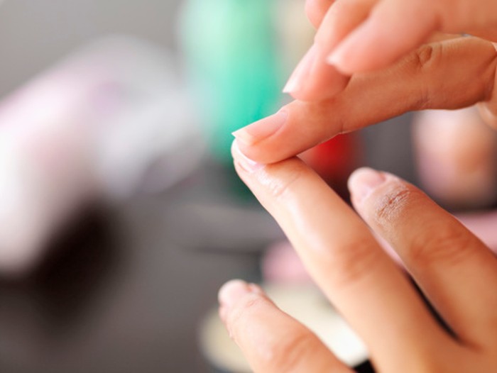 Woman applying lotion to cuticles