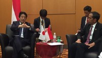 Tak hanya berjabat tangan, Jokowi juga terlihat berbincang bersama Abe. Pool/Birosetpres/Cahyo.