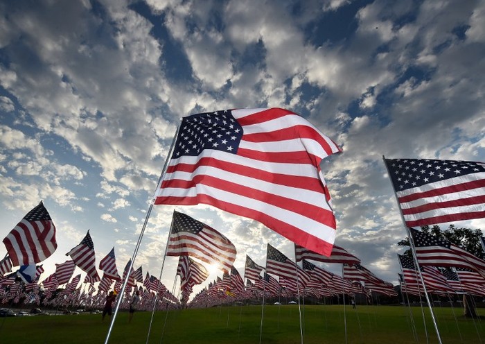 People walk amongst US national flags erected by students and staff from Pepperdine University to honor the victims of the September 11, 2001 attacks in New York, at their campus in Malibu, California on September 10, 2015. The students placed some 3,000 flags in the ground in tribute to the nearly 3,000 victims lost in the attacks almost 14 years ago.      AFP PHOTO / MARK RALSTON / AFP / MARK RALSTON