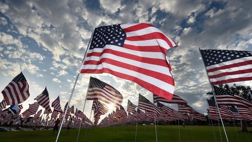 People walk amongst US national flags erected by students and staff from Pepperdine University to honor the victims of the September 11, 2001 attacks in New York, at their campus in Malibu, California on September 10, 2015. The students placed some 3,000 flags in the ground in tribute to the nearly 3,000 victims lost in the attacks almost 14 years ago.      AFP PHOTO / MARK RALSTON / AFP / MARK RALSTON