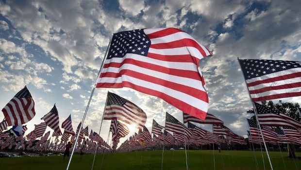 People walk amongst US national flags erected by students and staff from Pepperdine University to honor the victims of the September 11, 2001 attacks in New York, at their campus in Malibu, California on September 10, 2015. The students placed some 3,000 flags in the ground in tribute to the nearly 3,000 victims lost in the attacks almost 14 years ago. AFP PHOTO / MARK RALSTON / AFP / MARK RALSTON