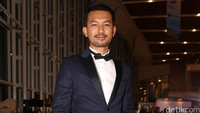 Rio memilih tampil kenakan kemeja putih, dasi kupu-kupu, setelan jas biru dongker dan sepatu oxford hitam.