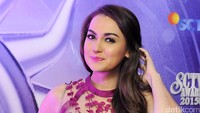 Ia pun memoles bibirnya dengan lipstik berwarna senada dengan dress yang dikenakannya. Pool/Noel/detikFoto.