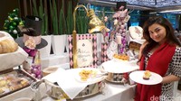 Wanita berusia 19 tahun itu juga mencicipi berbagai kue manis yang tersaji.