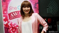 Ia terlihat cantik tampil chic dibalut blus putih dipadu outerwear pink, celana putih, dan heels pink. Pool/Gus Mun/detikFoto.