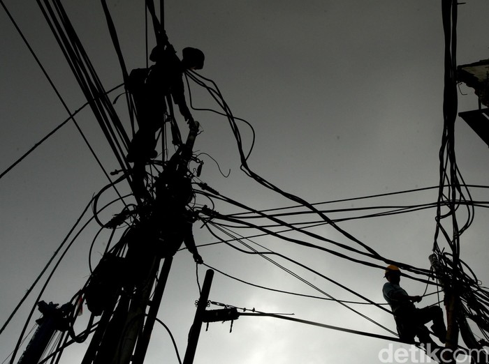 Perawatan kabel Telekomunikasi --- Pekerja melakukan perawatan kabel telekomunikasi di kawasan Pasar Blok A di Jalan Fatmawati, Jakarta, Senin (7/12/2015). (Ari Saputra/detikcom)
