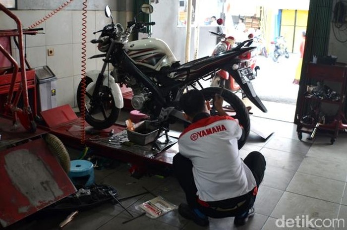 Motor-motor tengah dirawat/diservis di diler Yamaha.