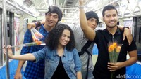 Tak cuma membagi-bagi bunga, mereka juga asyik mengamen bersama Wizzy.