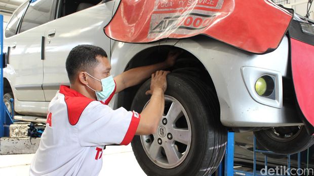 Mekanik mengecek kaki-kaki mobil