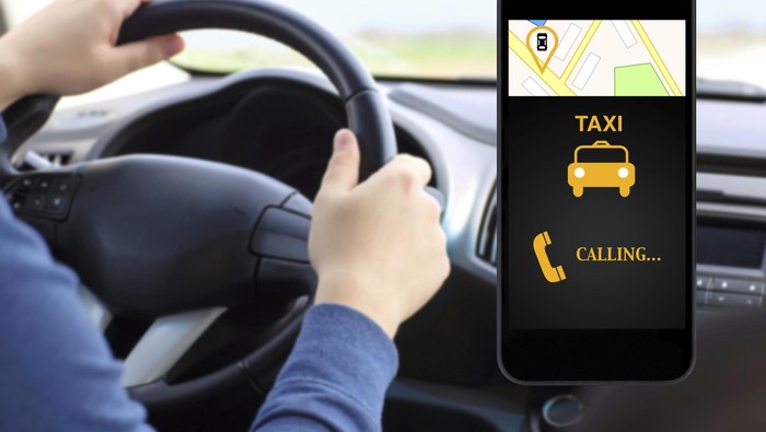 phone with interface taxi on a screen background man drivin