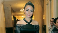Ia tampil dibalut dress, clutch bag, dan heels berwarna hitam.