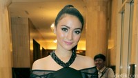 Lipstik pink di bibirnya menyentuh penampilan serba hitamnya.