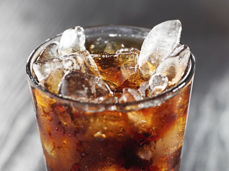 Segelas kola dengan es batu.