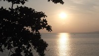 Dari Desa Eri, kala senja hanya terlihat matahari dan lautan luas tanpa latar pegunungan. Traveler bisa memarkirkan kendaraan di pinggir jalan (karena belum tersedia tempat parkir) dan duduk-duduk di pantainya (Afif/detikTravel)