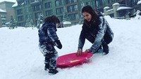 Bermain di tengah salju, si kecil El tak ketinggalan untuk berseluncur dengan papan seluncur. (Instagram/jedarcantik)