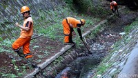 Petugas PPSU pun nampak bahu-membahu, membersihkan sampah dan rumput liar di Sodetan Kali, di Jalan Raya Hankam, Bambu Apus, Jakarta Timur.