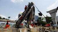 Petugas berusaha mengevakuasi baliho yang tumbang tersebut.