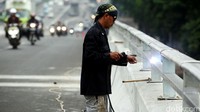 Meski sudah dapat dilalui, seorang pekerja tampak masih menyelesaikan perkerjaan akhir proyek flyover senilai Rp 137 miliar tersebut.
