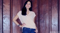 Nina Zatulini dengan gaya kasualnya mengenakan blus peach dipadu dengan jeans biru.