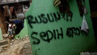 Seorang warga membongkar rumahnya menggunakan palu.