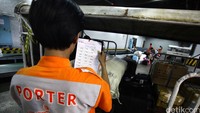 Porter melakukan pengecekan sebelum barang dimasukkan ke pesawat.
