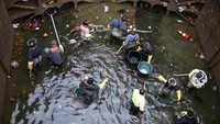 Sejumlah pekerja menangkap ikan saat melakukan pembersihan kanal Saint-Martin. Charles Platiau/Reuters/detikFoto.