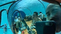 Mereka menyantap makanan mereka di bawah laut. (Instagram/ashrafsinclair)
