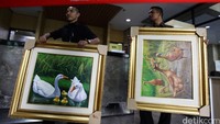 Petugas KPK memindahkan lukisan yang diterima dari Kementerian Pertanian.