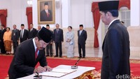 Djoko Setiadi menandatangani berita acara pelantikan dengan disaksikan Presiden Jokowi. (Lemsaneg). Kris/Setpres/detikFoto.
