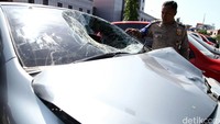 Polisi memeriksa kaca depan yang pecah.