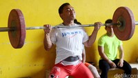Atlet pelatnas angkat besi tampak serius berlatih.